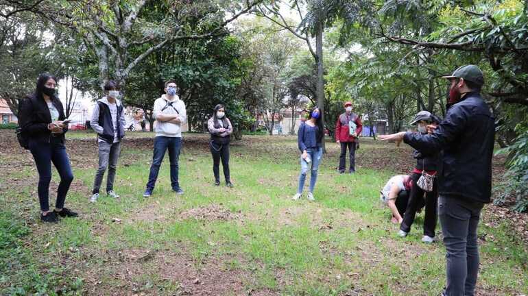 Participantes de recorrido ambiental participan en charla sobre la flora y la fauna de la ciudad.